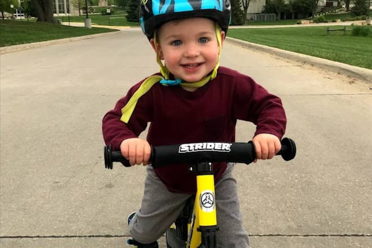 Owen Tudor, a young boy, rides his yellow Strider bike