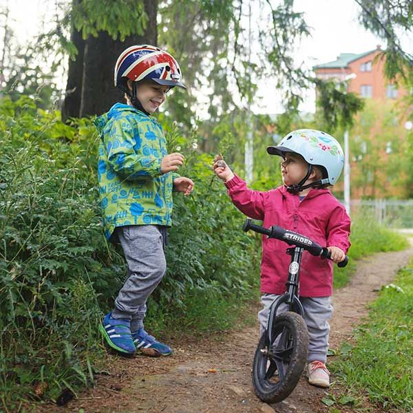 Children look at plants while out for a ride on Strider bike