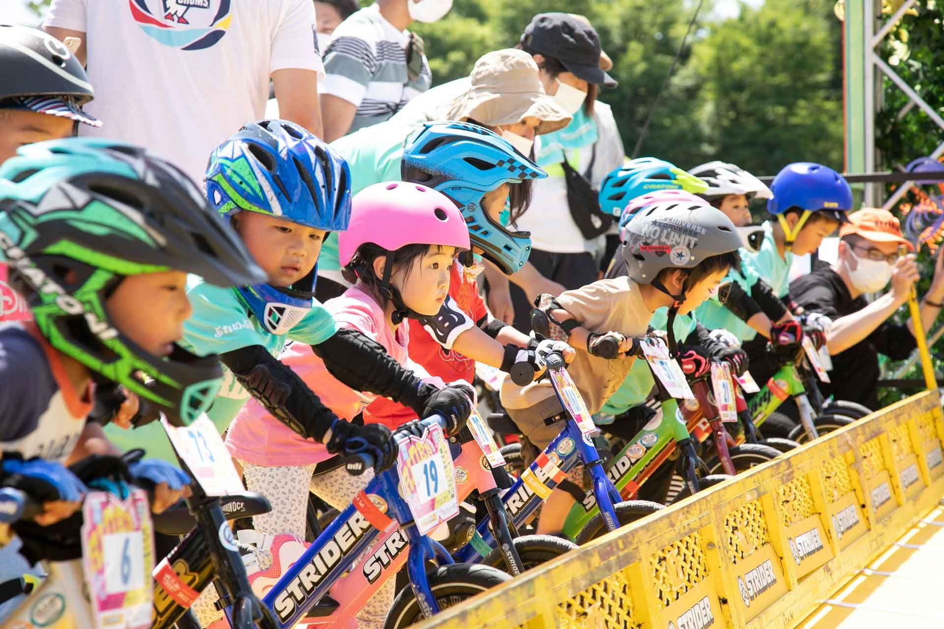 Racers stare forward at the starting gate of a Strider Cup race