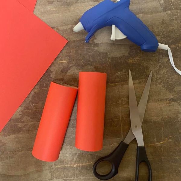 Gluing construction paper to toilet paper rolls