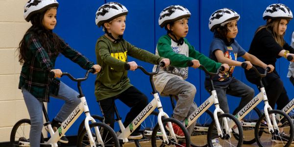 Children line up on bikes ready to take part in the All Kids Bike Kindergarten PE Program