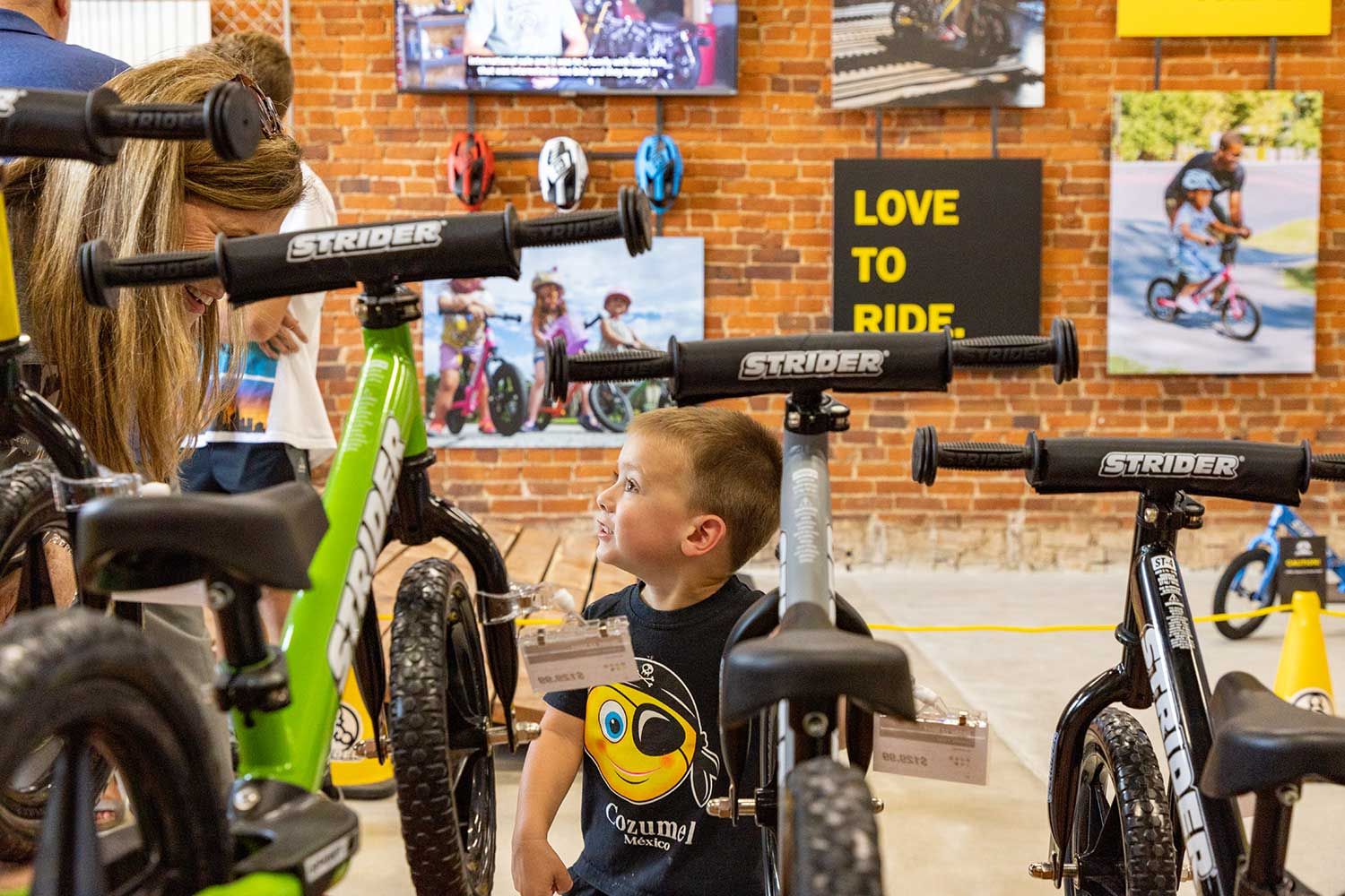 A young boy looks at a Strider balance bike in the Bentonville, Arkansas, Strider Store