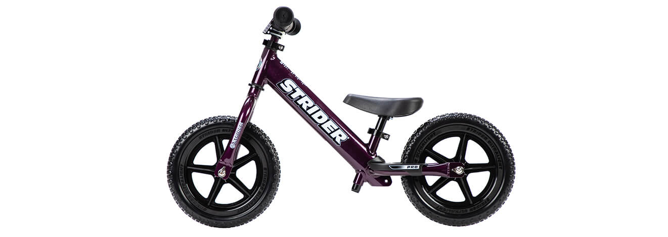 A studio profile picture of a purple Strider 12 Pro balance bike