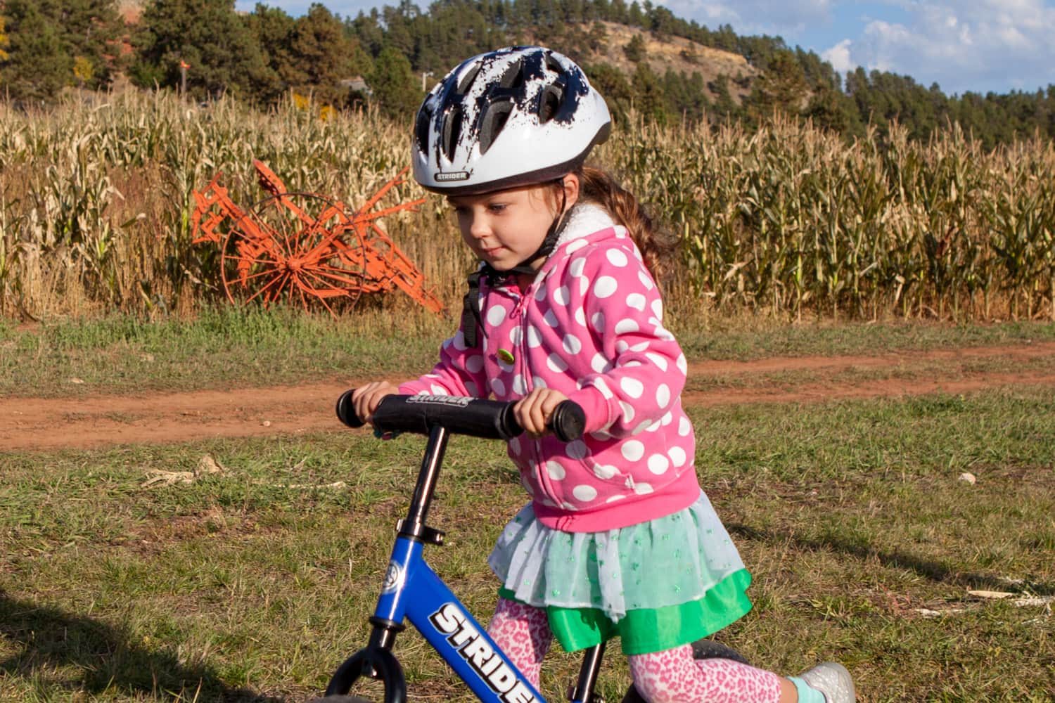 Girl riding a bike in a Strider Splash helmet