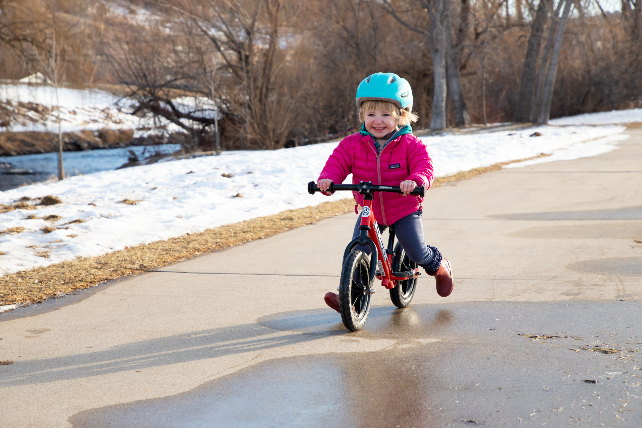 Toddler girl smiling and striding on red 12 Sport with ST-R stem adapter on Aluminum Flat Handlebar