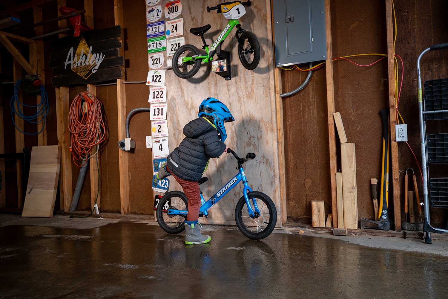 A child in a garage gets on a bike with a Memory Mount installed above