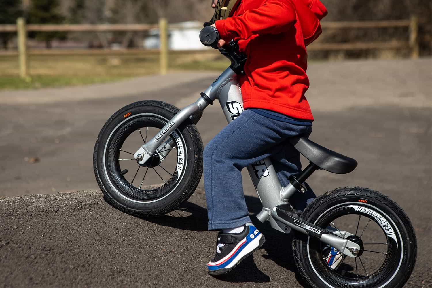 Close up of Strider ST-R carbon wheels in action on a silver balance bike