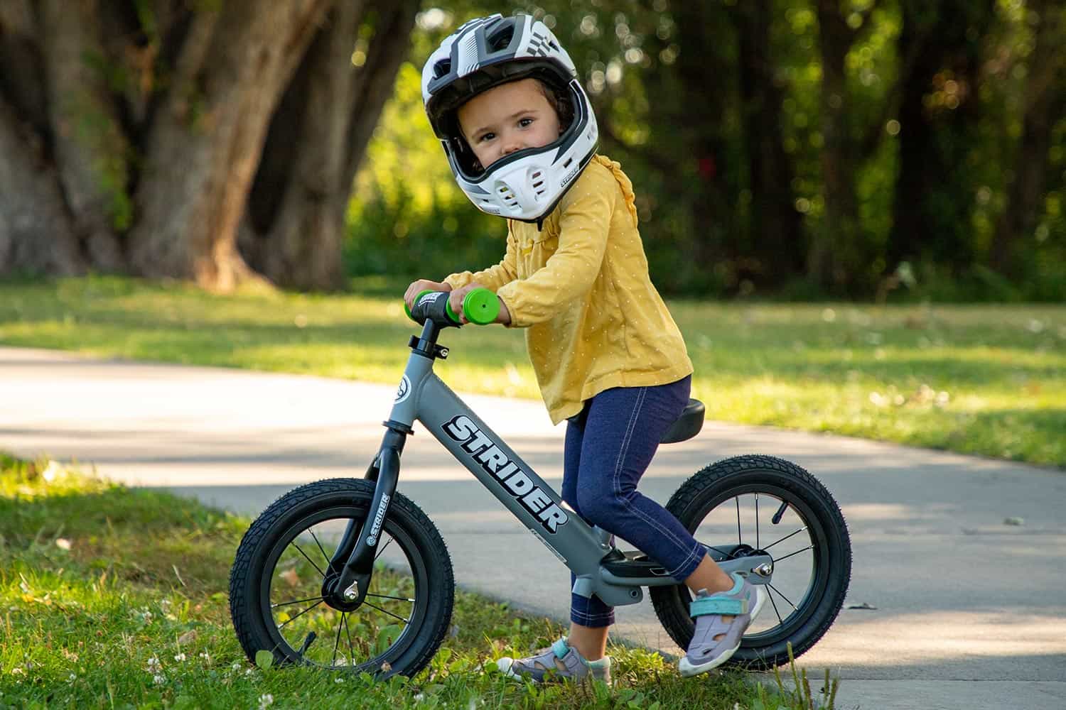 A girl in a Strider ST-R helmet riding a bike with high-traction pneumatic wheels