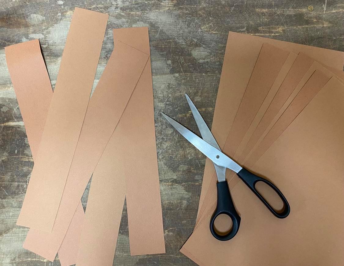 Scissors next to strips of brown paper