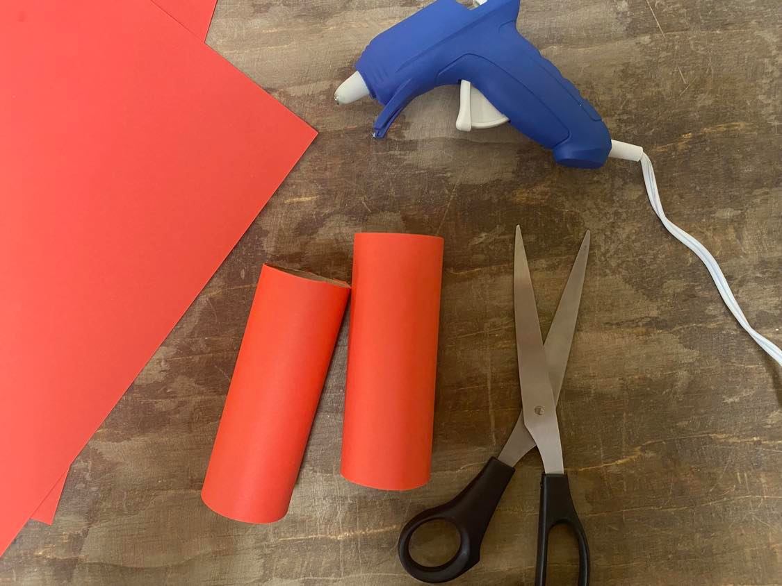 Gluing construction paper to toilet paper rolls